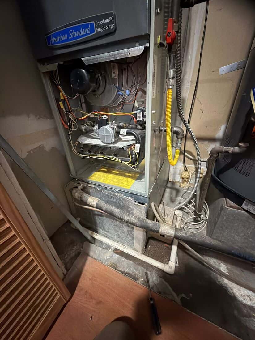 Furnace opened for service showing the gas valve, burner assembly, and wiring