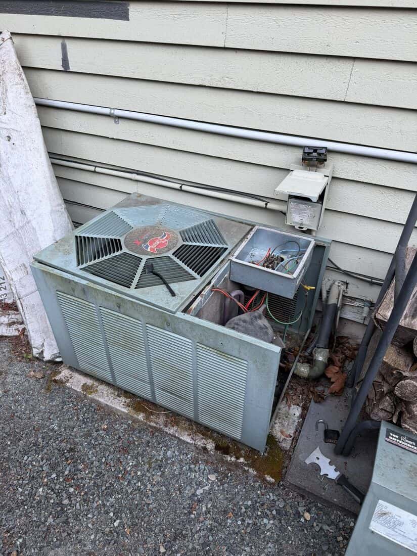 Ground mounted packaged HVAC unit beside a light commercial building